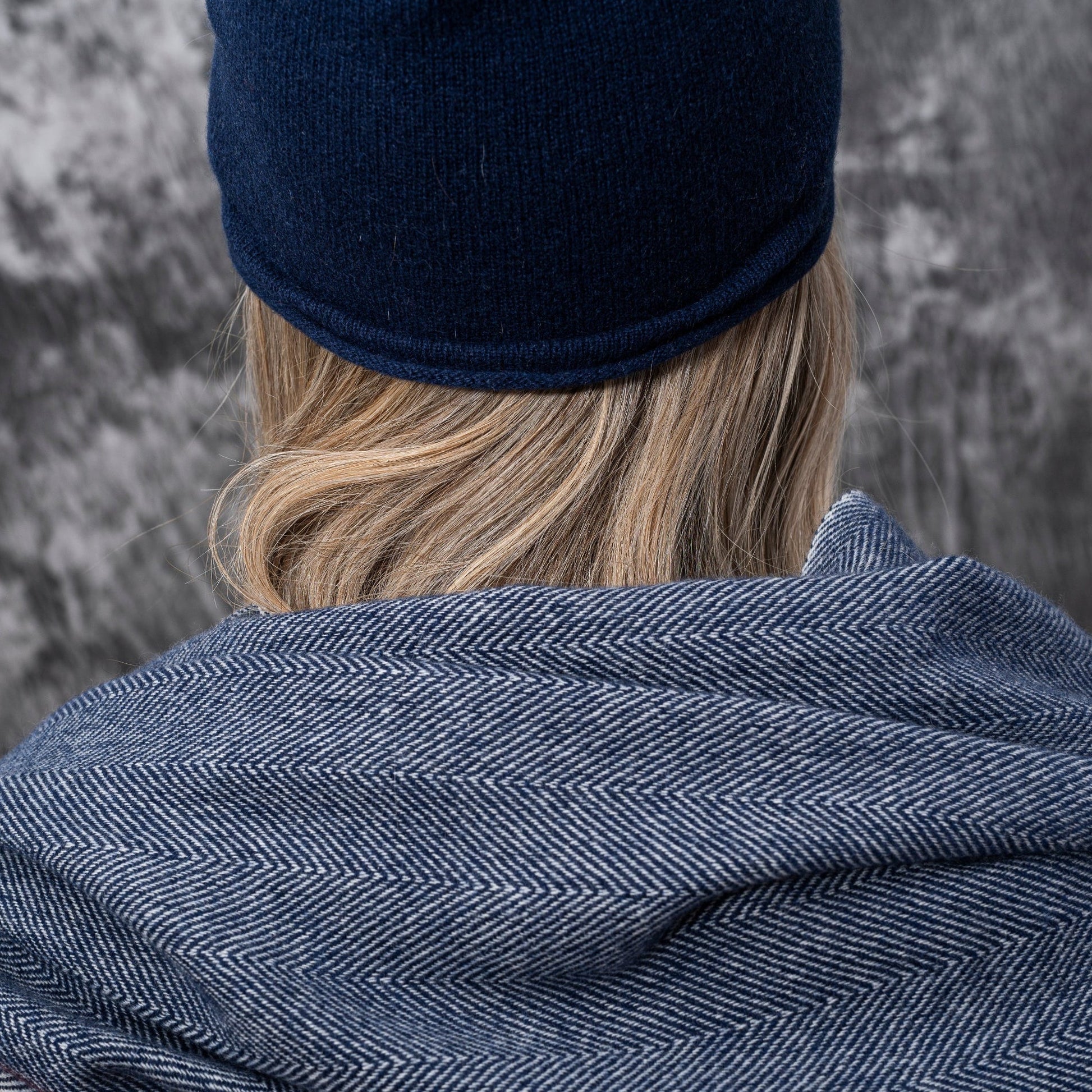 A closeup of a woman wearing cashmere Lightweight Reverse Knit Cap by Rayaa in Snow white color