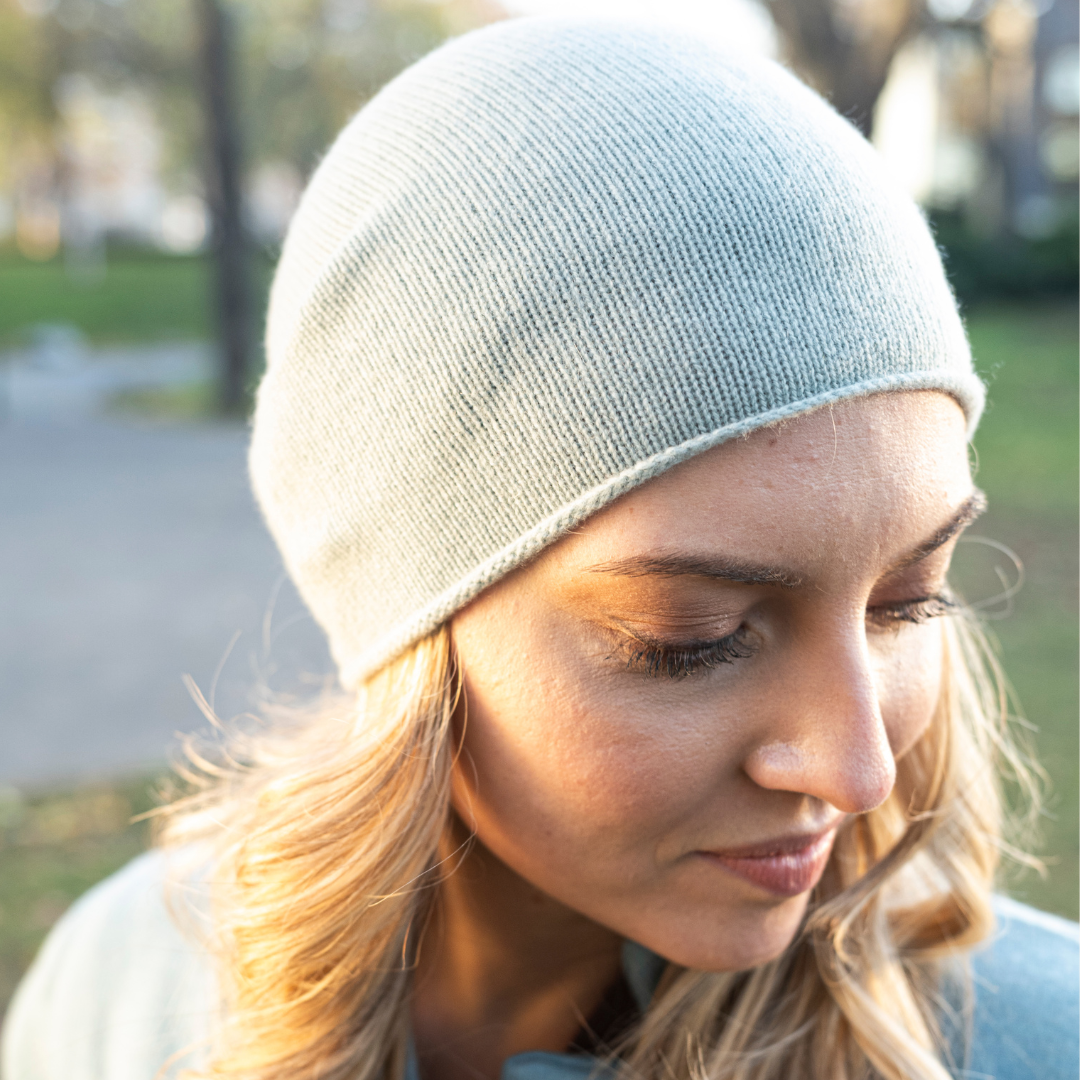 A closeup of a woman wearing cashmere Lightweight Reverse Knit Cap by Rayaa