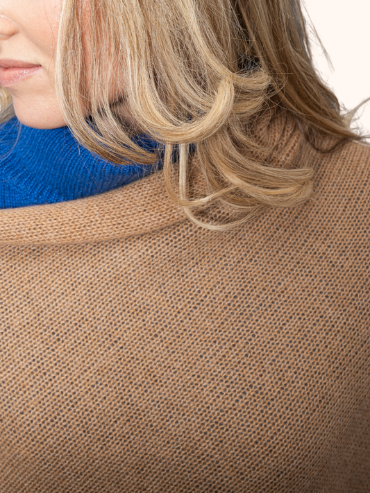 Woman wearing a stylish cashmere Poncho by Rayaa, showcasing an elegant and flattering silhouette. Closeup 