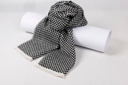 Cashmere Herringbone Narrow Shawl in black and white, draped elegantly on a rolled white surface.
